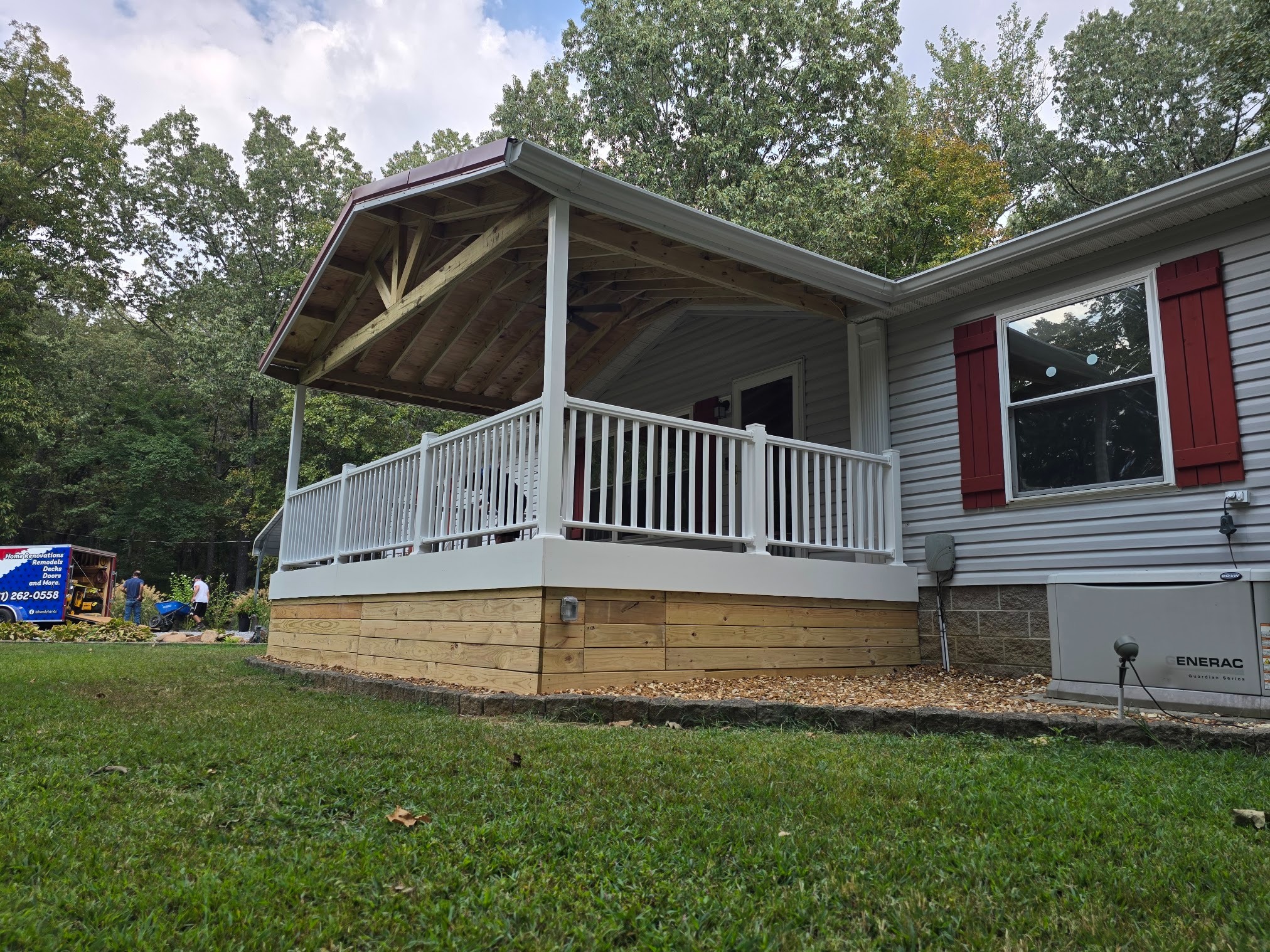 Covered residential deck with white railing and gable roof