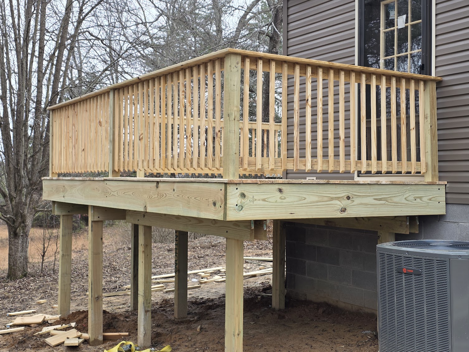 New raised pressure-treated wood deck with custom railing
