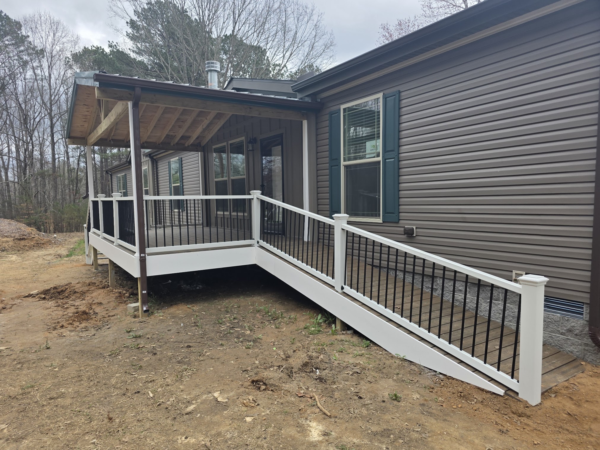 Covered deck with a long accessibility ramp and black railing