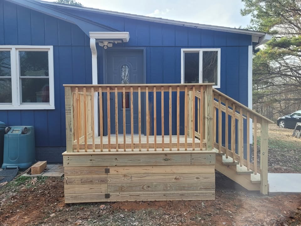 Small residential deck with stairs beside a blue home
